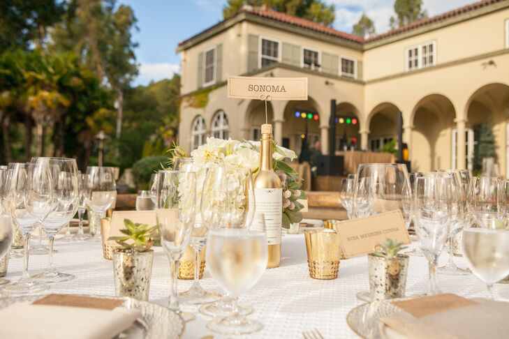 At the outdoor reception at Chateau St. Jean Winery in Kenwood, California, a combination of round and farm tables were topped with crisp white linens and gold mercury-glass vases.
