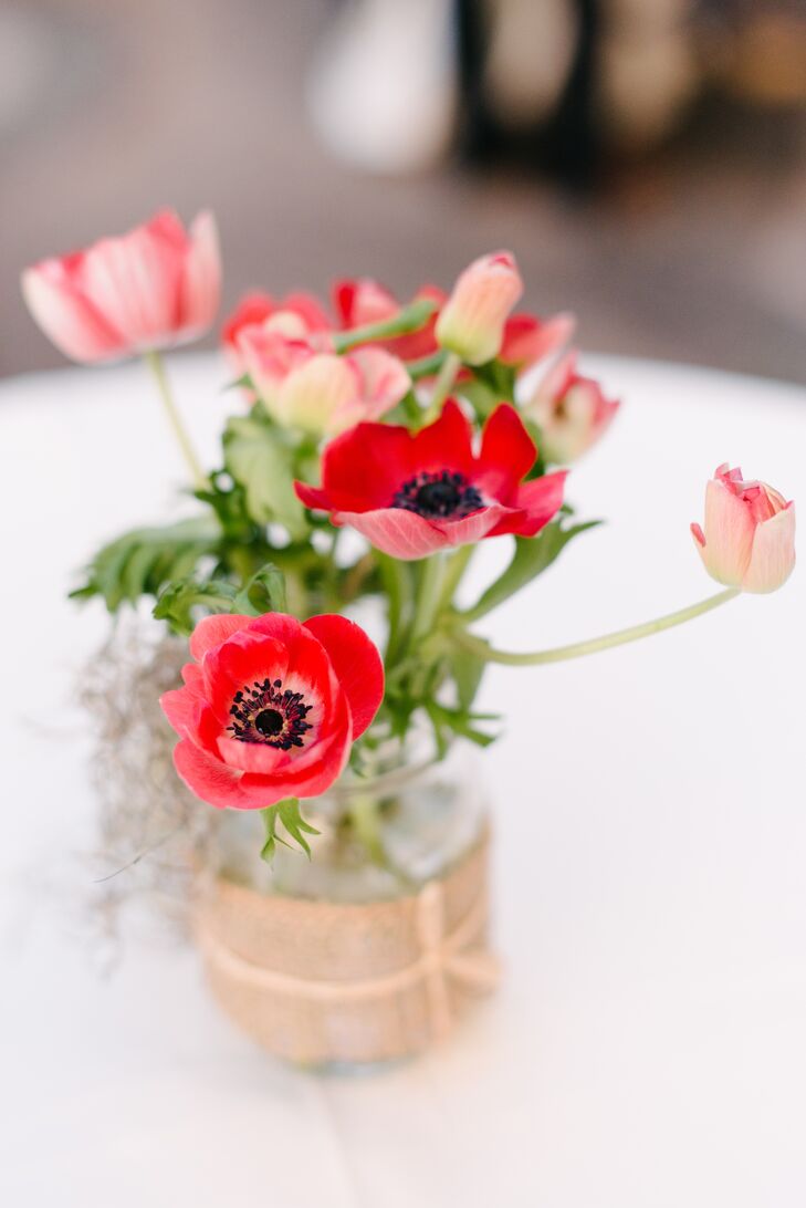 In order to enhance their elegant-meets-shabby chic decor, the couple topped lace linens with mason jars filled with mixed clusters of vibrant blooms.