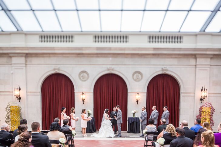 Elon and Justin stood at the altar surrounded by their wedding party during their ceremony, which took place at the Columbus Museum of Art in Columbus, Ohio. "The glass ceiling of the museum provided us with a feel of being outdoors without having to worry about rain," the couple says. "It turned out to be a great decision as it rained up until our ceremony that day."