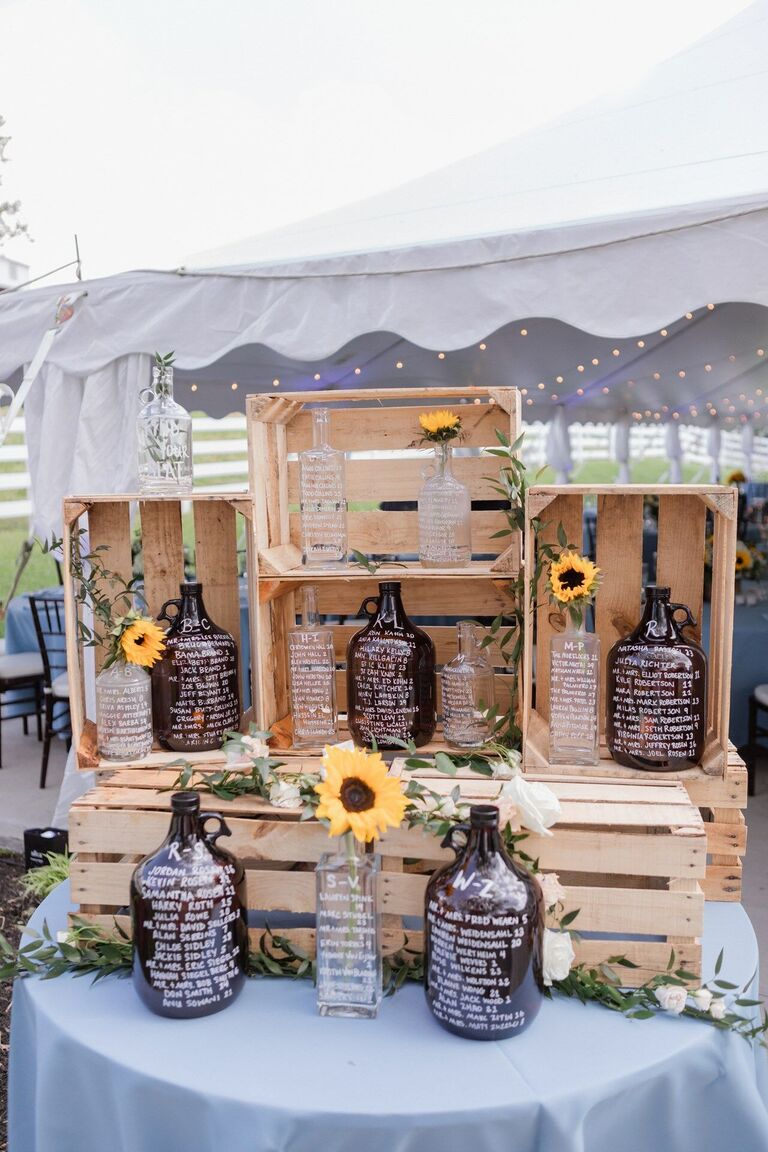 Seating chart display with crate and bottles accented by sunflowers