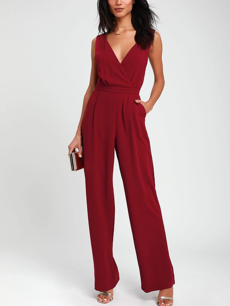 Model wearing a red jumpsuit with pockets and a v-neckline