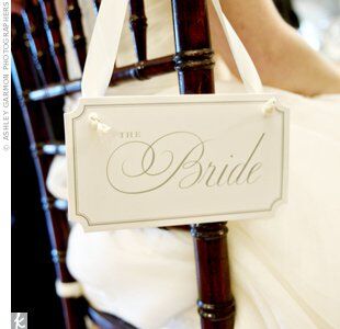Hanging bride and groom signs were playful additions to Dixie and George’s reception chairs—and let guests know where the couple would be sitting.