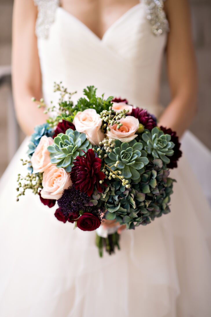 “I just wanted our wedding to be simple and romantic, so we went with a lot of candles to add some sparkle and white flowers with a touch of burgundy for the floral arrangements,” Lauren says. For the bridal bouquet, Blossom Floral created a bountiful bundle of succulents, hydrangeas, scabiosas, dahlias and roses in dramatic shades of burgundy, blush, purple and green that popped against the pale blush organza of Lauren’s Hayley Paige dress.