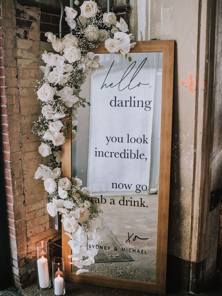 Mirrored wedding signage with white floral garland decoration