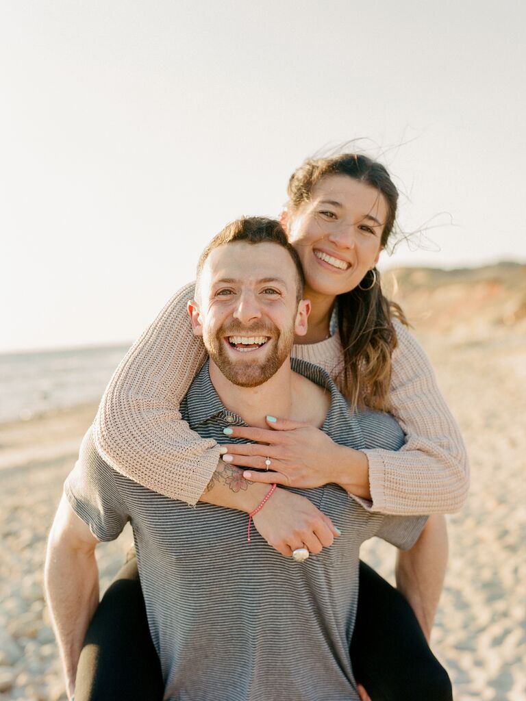 Couple poses on a sandy beach. 