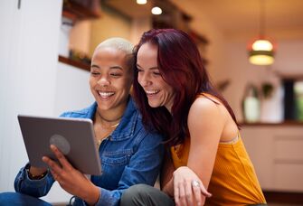 Couple smiling and using tablet computer