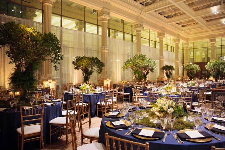 Drawing on the venue for inspiration, as well as what Linsey refers to as “the eerie feel” of the season, the couple dreamed up an enchanted woodland theme for the evening, complete with a rich color palette of moody black and blue hues, statement-making moss, succulent and floral centerpieces made by Poppies Design Studio and plenty of gilded details and warm candlelight. “Visually, I wanted people to feel like they were in the woods and stumbled upon some dream-like dinner party,” says Linsey