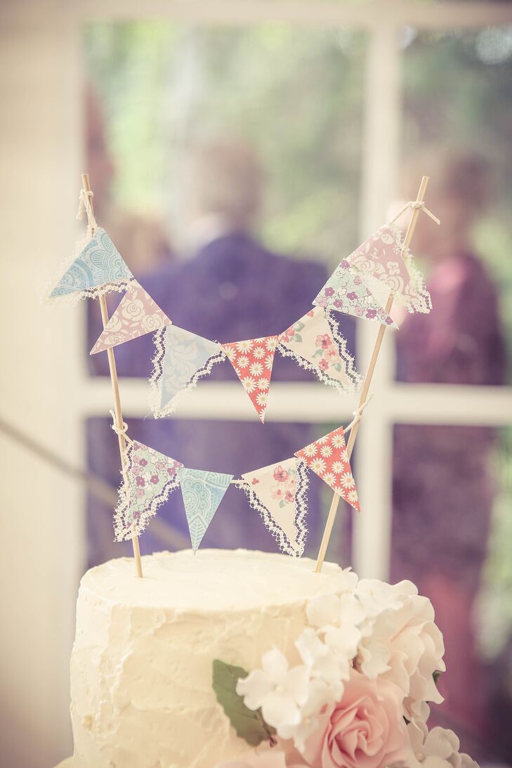 A vintage bunting flag cake topper added a cute touch to the three-tier white buttercream-frosted cake.