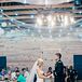 For their first dance, Samantha and Chris selected "I Don't Dance" by Lee Brice. String lights and an iron chandelier created a romantic glow inside the rustic wooden reception barn.