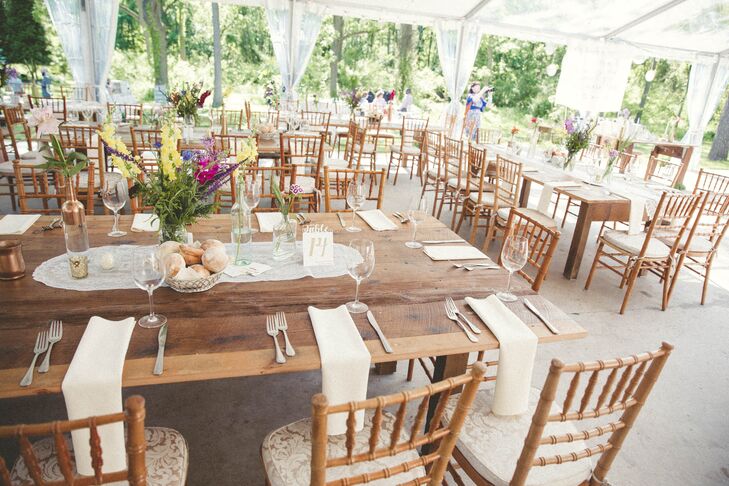 Having a love for all things floral, lace and gold, Lauren designed their reception to feature all three details. Each family-style table had a chic lace runner, classic white napkins and a lush arrangement from Risher Van Horn Flowers. Bright fuchsia and yellow delphiniums, greenery, purple astilbes and wildflowers all popped from vintage-style glass and copper vases along the tablescape. The couple’s sheer white tent highlighted the space.