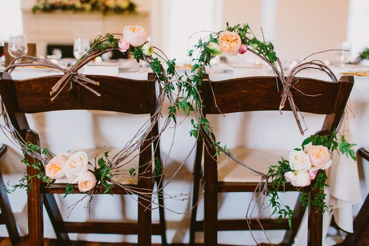 Handmade heart wreaths made with fresh flowers were positioned on the back of the bride and groom's chairs at the reception.