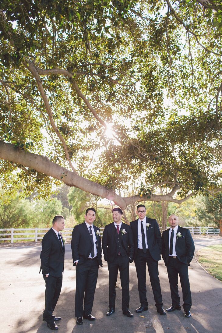 Groomsmen donned traditional black suits with matching ties and boutonnieres, while Emmanuel sported an extra piece in his vest.