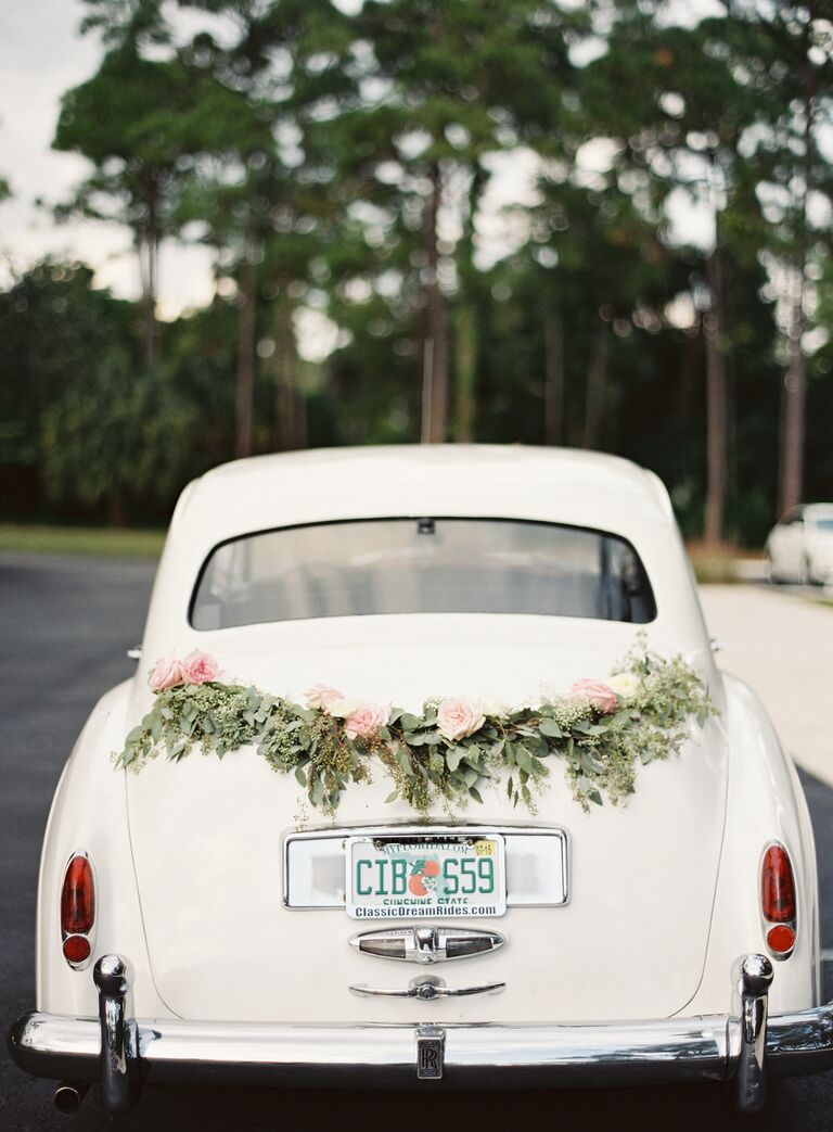 White exit car with green garland and roses