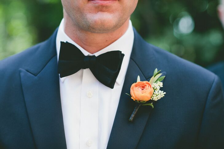 A bright orange ranunculus popped against Aaron's navy tuxedo.