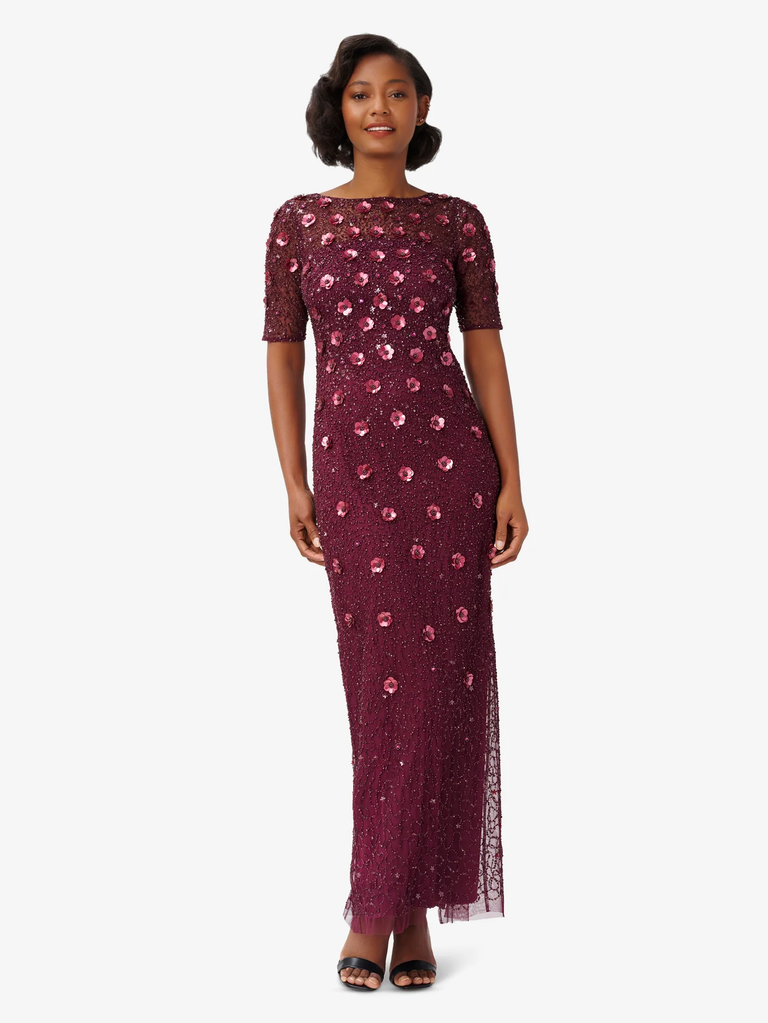 A model shows off this floor-length gown with glamorous appliqué.
