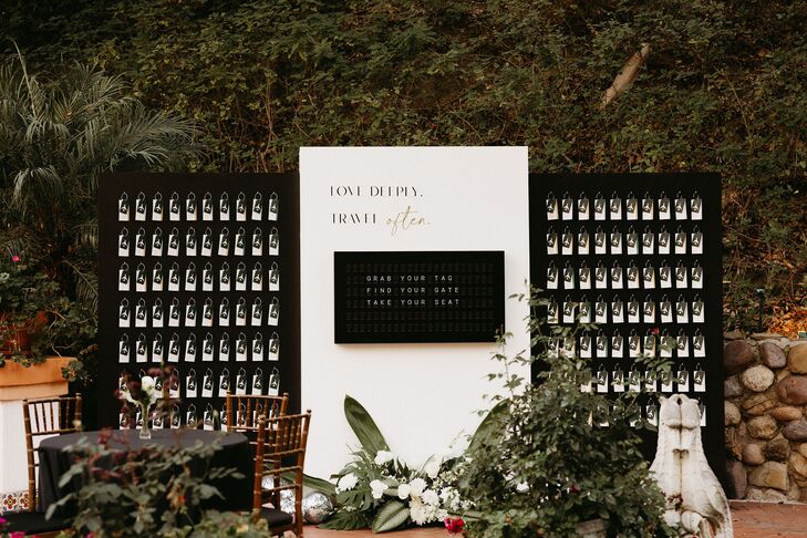 Unique escort card display modeled after the "Arrivals" and "Departures" board at an airport with a retro feel, also featuring a Vestaboard with custom messages to guests and escort cards styled as luggage tags for their elegant, black-tie reception.