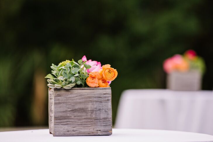 The outdoor cocktail tables had their own natural accents. Each was set with bright orange ranunculus, greenery, succulents and pink peonies inside a wooden breakaway vase.