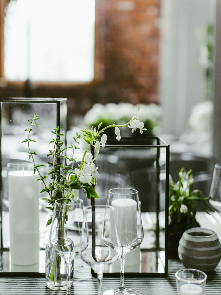 modern minimalist wedding centerpiece with white candles in rectangular glass boxes with white flowers in bud vase