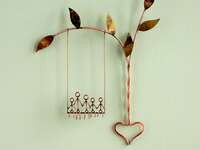 Copper wire sculpture of family on a swing