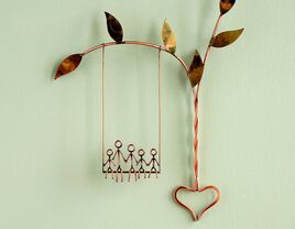 Copper wire sculpture of family on a swing