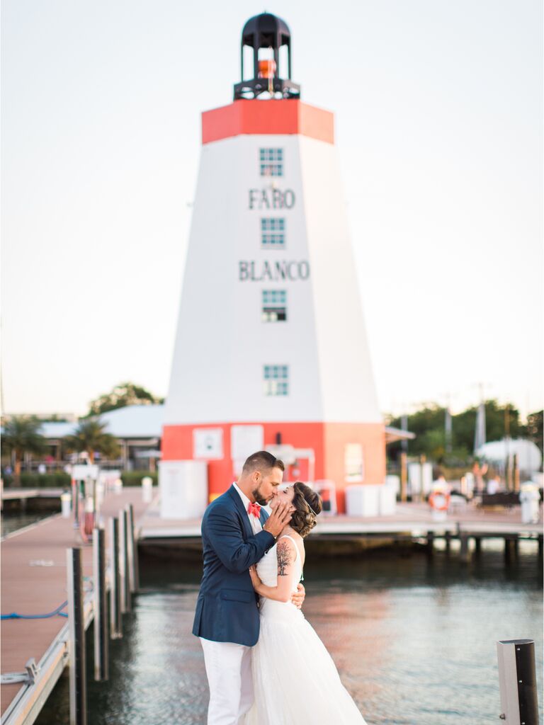 married couple kissing in front of a lighthouse in florida