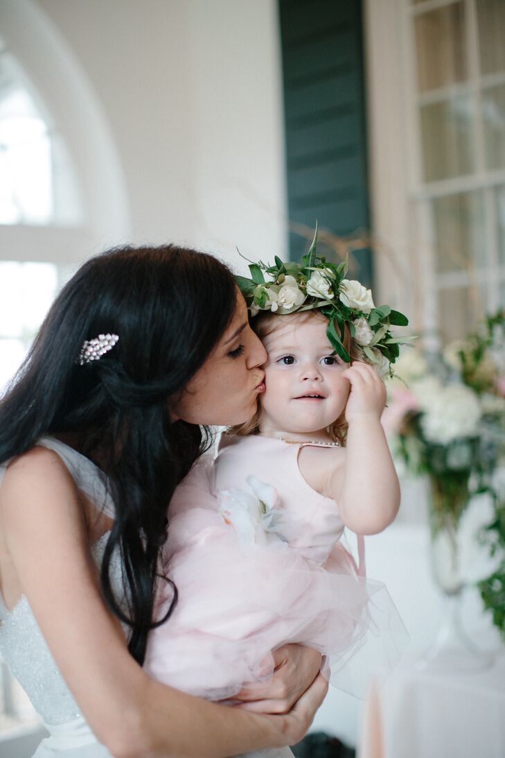 Nina and Tristan's flower girl wore a blush dress with a tulle skirt and a sash decorated with a large rose. Their florist, Branch Design Studio, created a flower crown for her to wear, including olive branches and roses hand-tied with a blush ribbon.