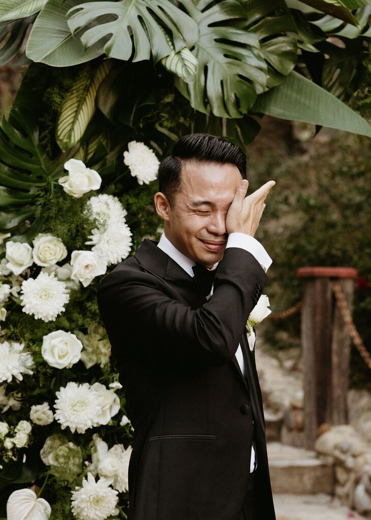 Groom in Classic Black Tuxedo Wiping Tears From His Eyes From Crying