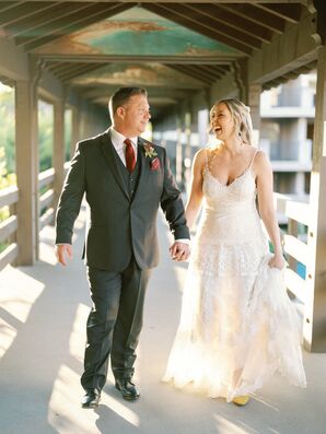 Bride in a Fitted A-Line Dress and Groom in Dark Gray Suit Hold Hands