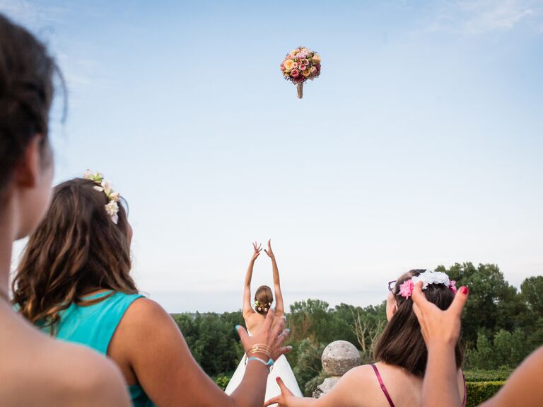 Bride throwing a bouquet to her wedding guests.