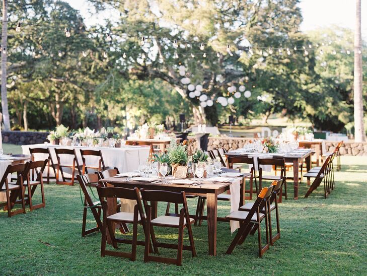 Natural ivory linens topped each wood table along with a mixed variety of candles, lanterns and centerpieces in the wood vessels. As for the ceremony maile leis? They doubled as chair decorations!