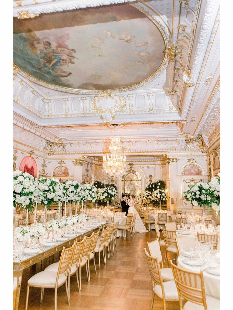 Bride and groom posing in opulent regencycore wedding venue