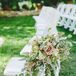 At the ceremony, white folding chairs that lined the aisle had overflowing flower arrangements filled with roses, eucalyptus and leafy greens—contributing to the overall garden-inspired theme of the day.
