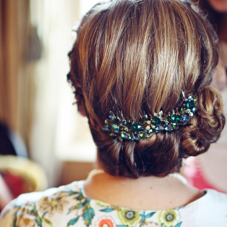 A beautiful swept-back hairstyle with a bedazzled hair pin. 