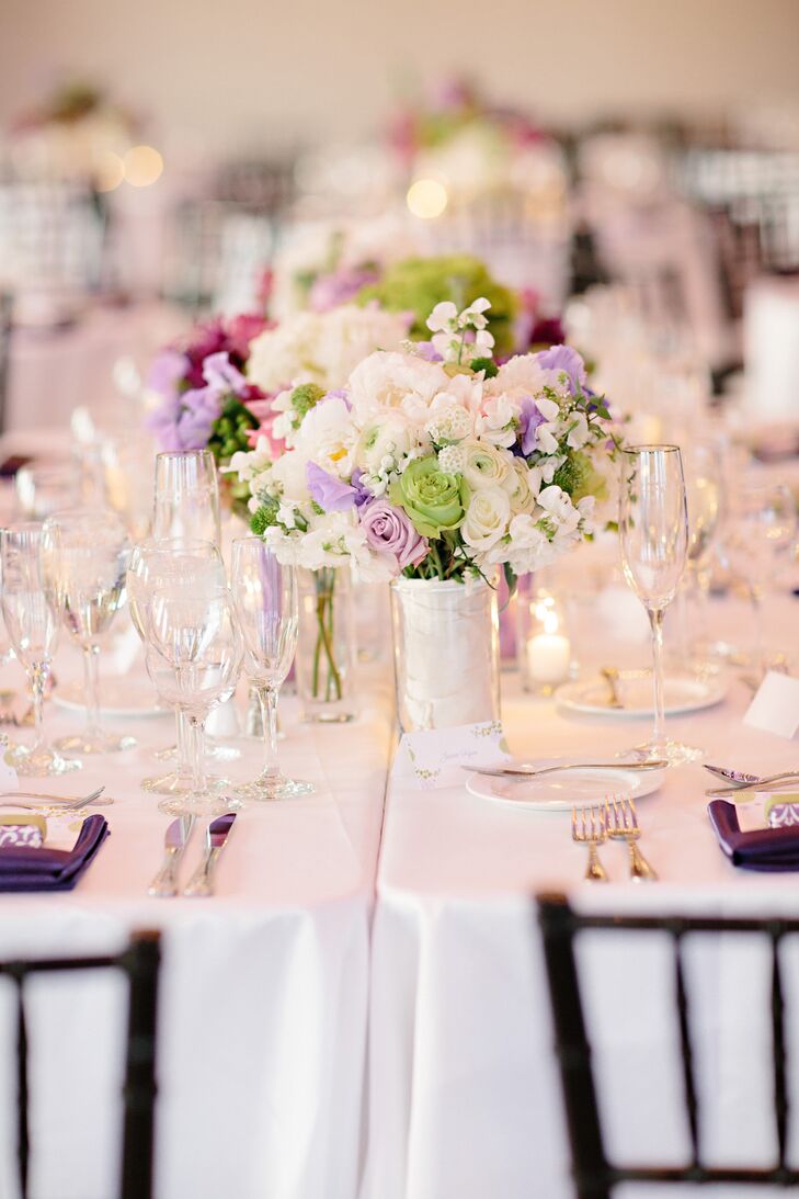 White roses, ranunculuses, peonies and stock were accented with pops of purple and green to complement the celebration's color palette.