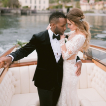 bride in long sleeve lace dress with groom on boat