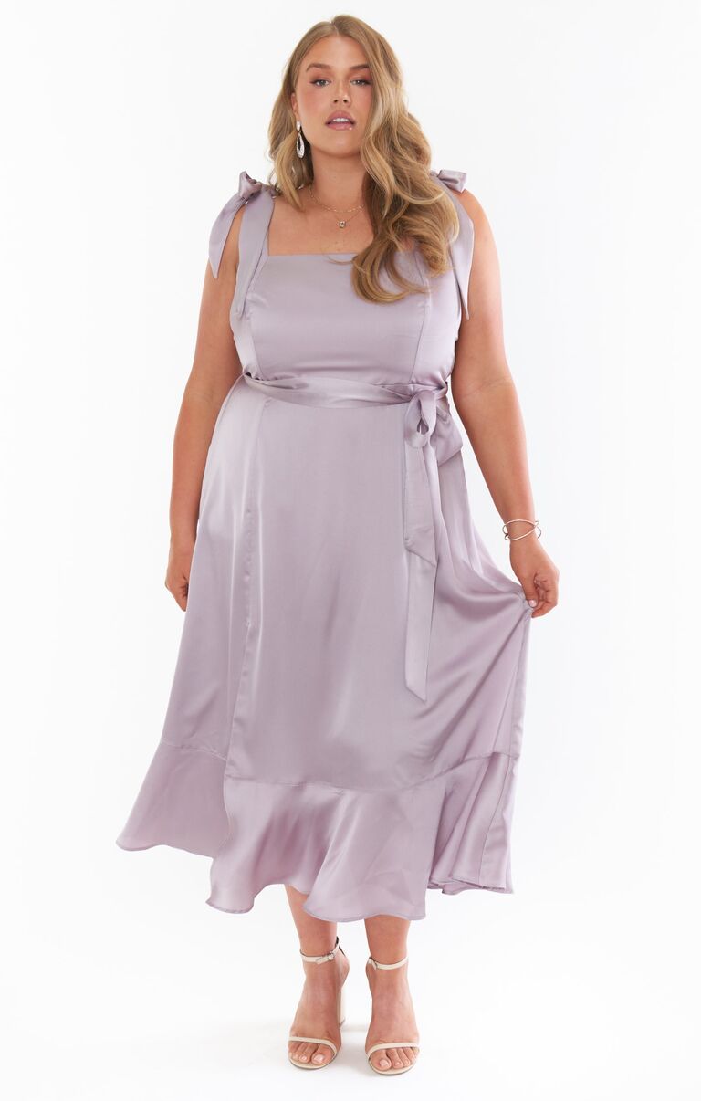 Model wears a mid-length purple silk gown. 