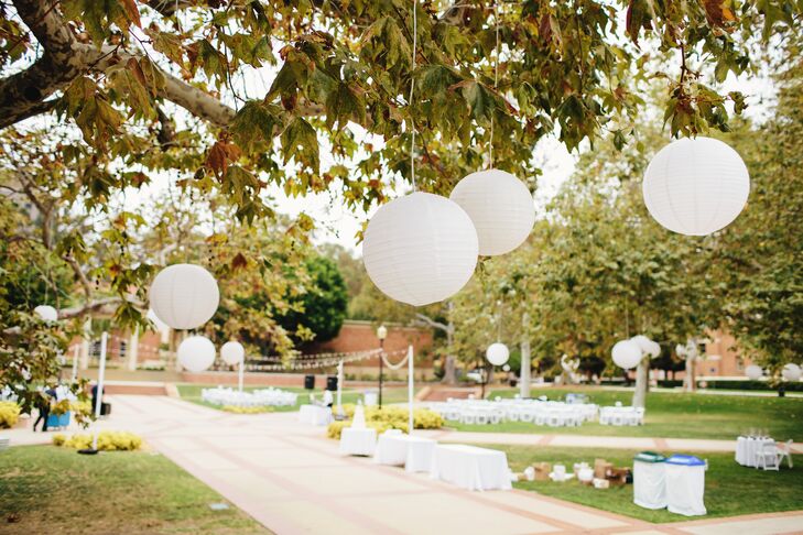 “We used mostly white decorations and accents. The flowers were all ivory or white garden roses, wrapped in ivory silk ribbon. The reception area was surrounded by large trees, so we hung large ivory lanterns from the trees for an elegant glow,” says the couple.