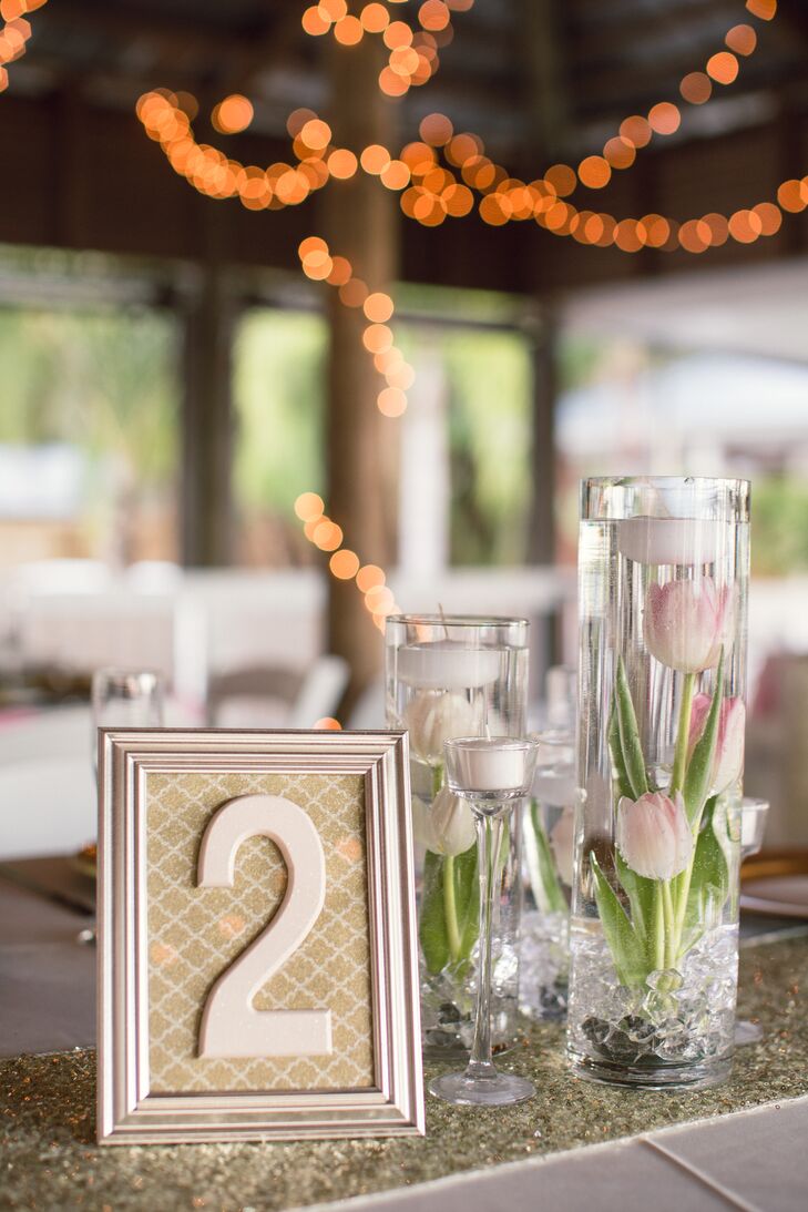 “Tulips are my absolute favorite flower, so I wanted them incorporated in the wedding,” Jami says. Each table was lined with a gold glitter runner below a trio of floating pink and white tulips. The cylinder vases also had white tealight candles above every flower for an elegant touch.