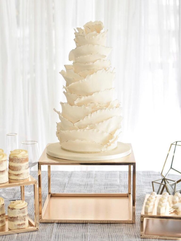 Large square metallic wedding cake base beneath tall cake