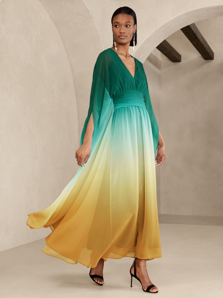 Model wearing a long-sleeve maxi dress with a V-neckline and shades of green and gold