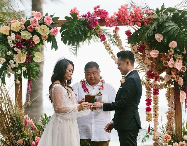 A couple standing together during their wedding ceremony with their officiant