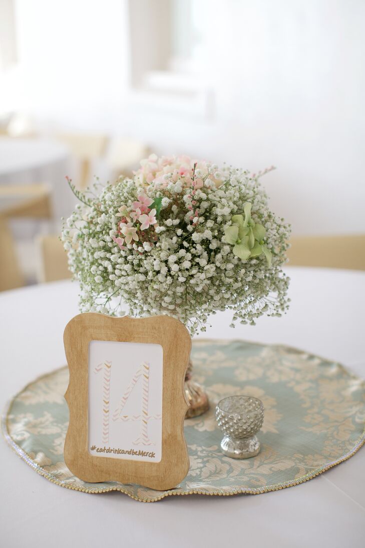 Floral centerpieces of baby's breath and hydrangeas in vintage metallic vases enhanced the Southern summer vibe at Kara and Nick's reception. Blush chevron table numbers in wooden frames, complete with their wedding hashtag, added a whimsical touch.