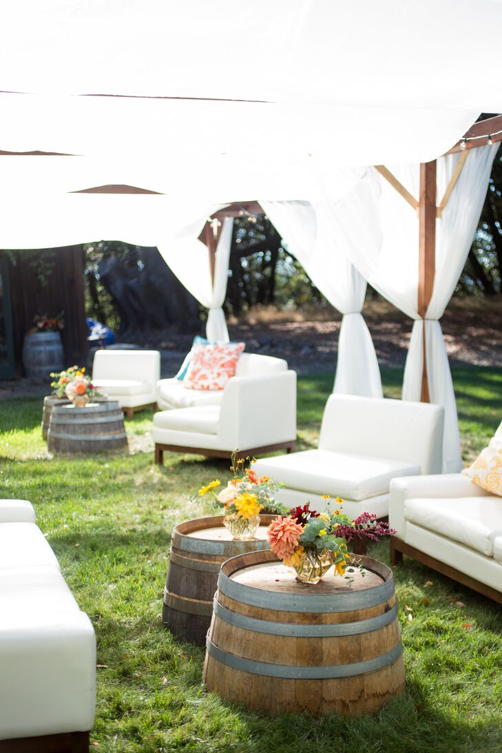 A breezy, shaded outdoor lounge area allowed guests to kick back with a beer or a cocktail after the ceremony. Wine barrels were topped with bundles of bright blossoms.