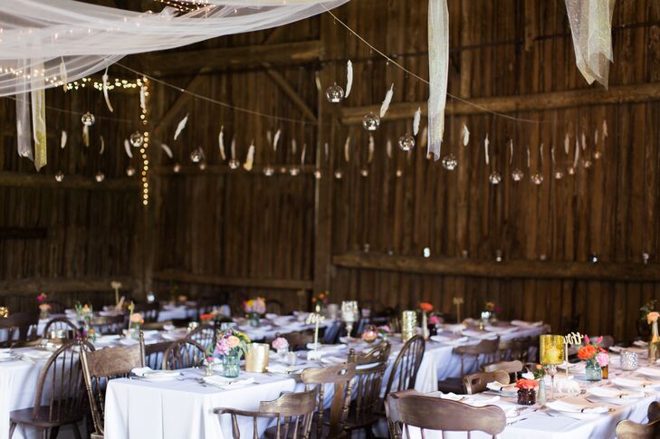Candles stood out atop white linen-draped tables, while bistro lights, lanterns and chandeliers illuminated the barn.