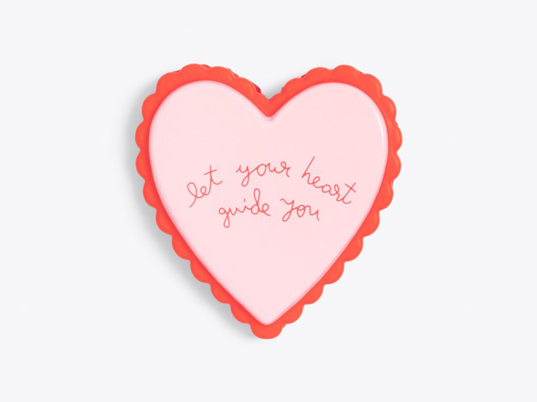 Pink heart stress ball with 'let your heart guide you' in red script