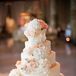 Amy Beck Cake Design created a five-tier white cake for the reception. It was decorated with piping, peach ribbon and cascading roses and hydrangeas.