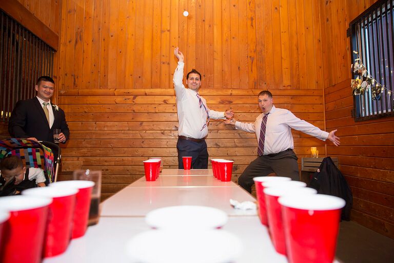 Wedding guests playing a drinking game of beer pong