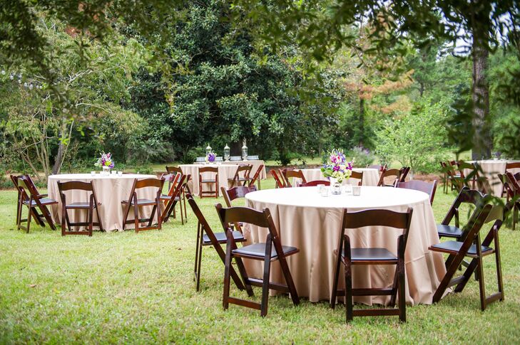 The reception decor featured neutral tablecloths, wooden folding chairs and purple floral arrangements.