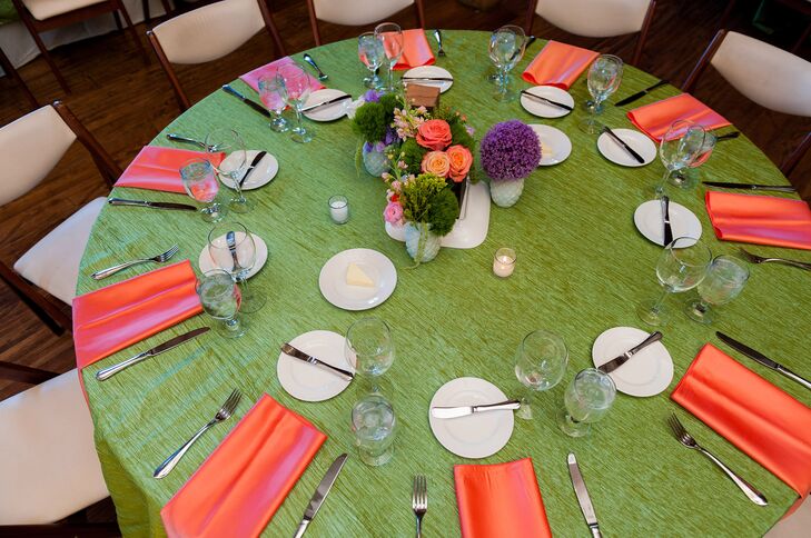 Katie and Haydn decorated their reception tables with green and orange linens and purple, green and orange floral arrangements.