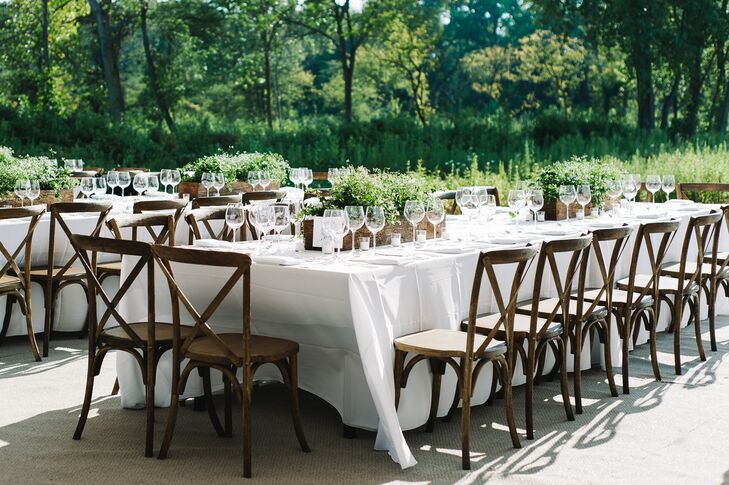 Long, dark wood tables were used to create a communal atmosphere among guests at the outdoor reception. The bride's father even built flower boxes that served as centerpieces while Anna's mom grew the ivy, white euphorbia and bacopa that filled each planter. The natural, simplistic aesthetic was completed using all-white linens and place settings.